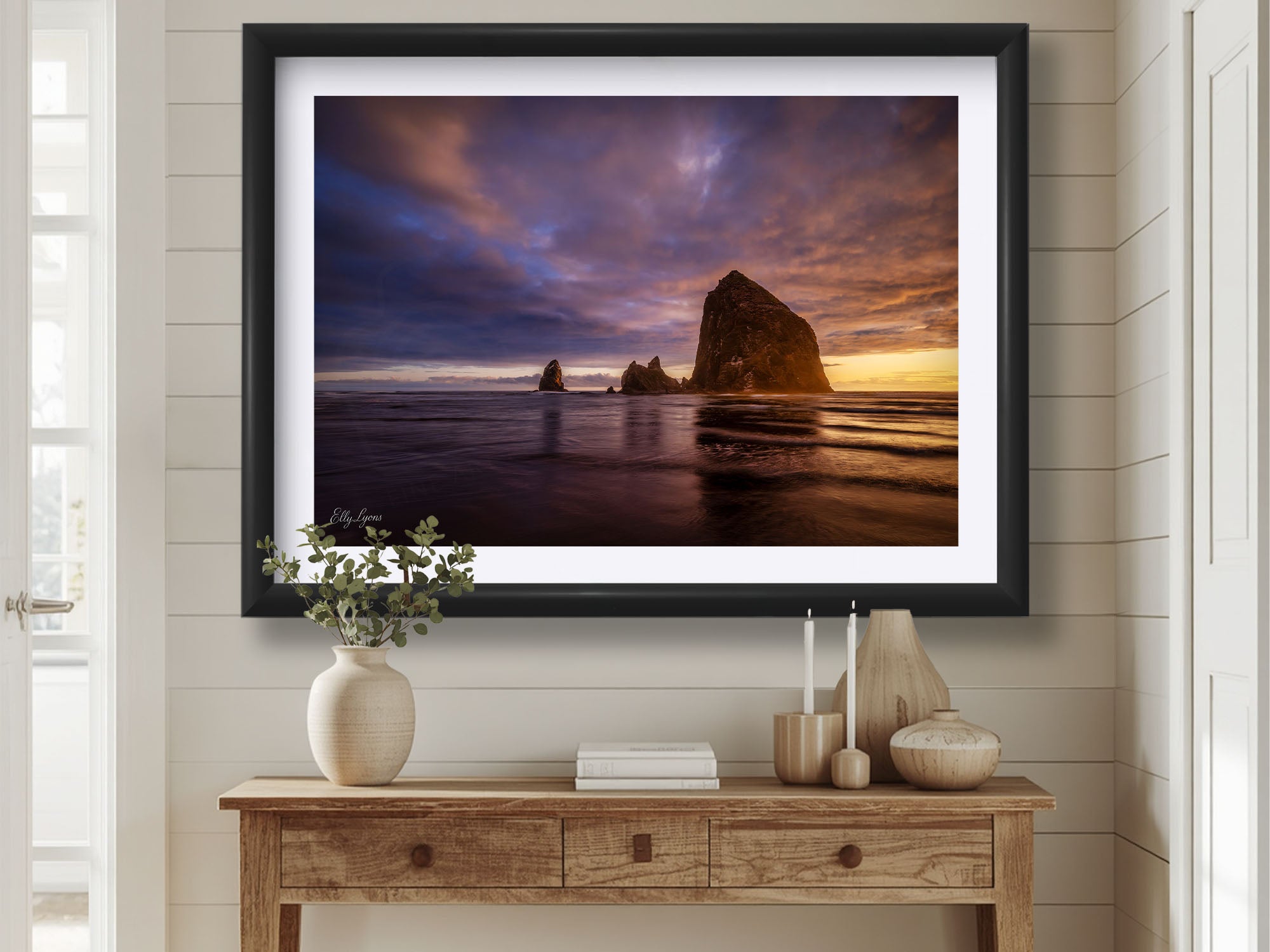 Canon Beach Oregon Haystack Rock sunset fine art print in black frame styled above a table in a bright entryway