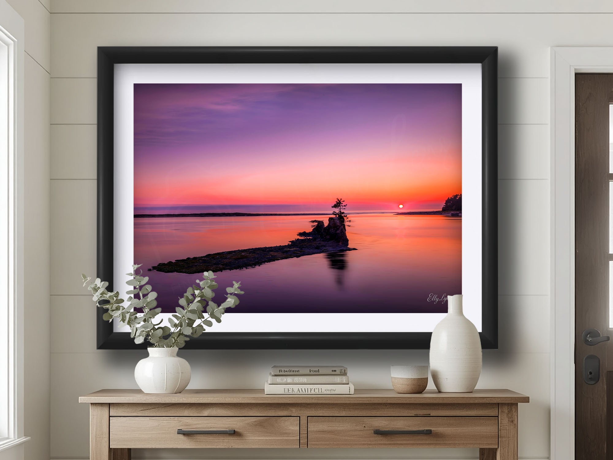 Pacific Northwest coast sunset fine art print in black frame styled above a table in a bright entryway