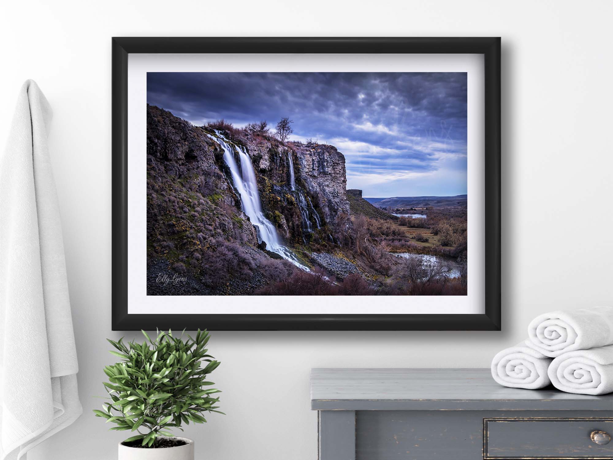Lemon Falls at Ritter Island, Idaho fine art print in black frame styled above a wooden cabinet in a bright bathroom