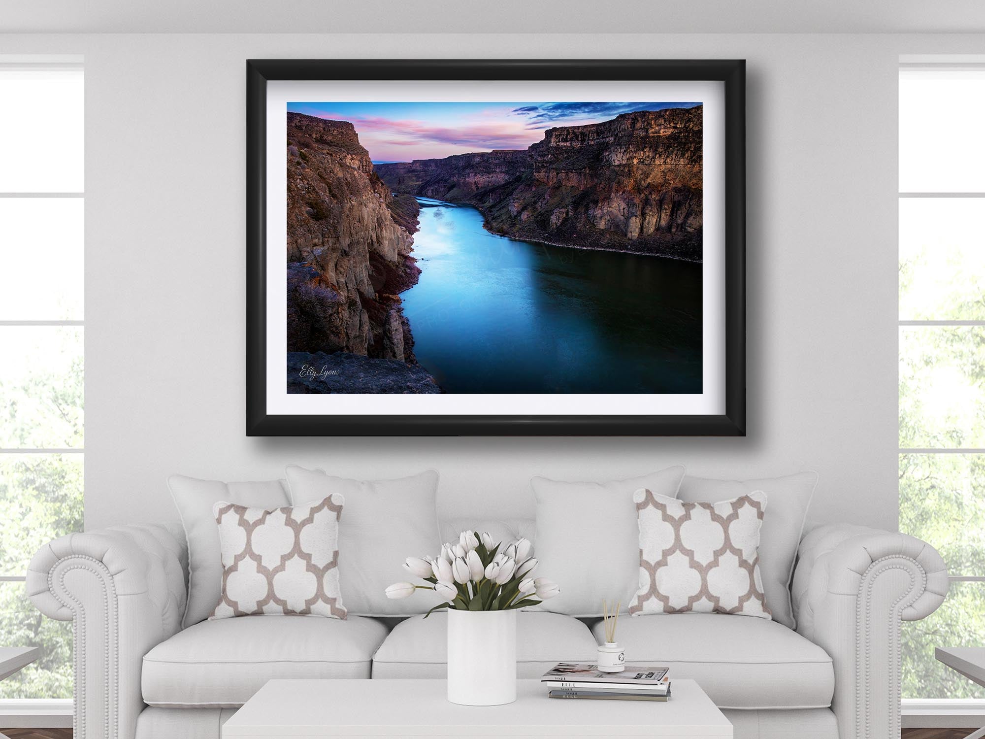 Snake River Canyon in Idaho at sunrise fine art print in black frame styled above a sofa in a bright living room
