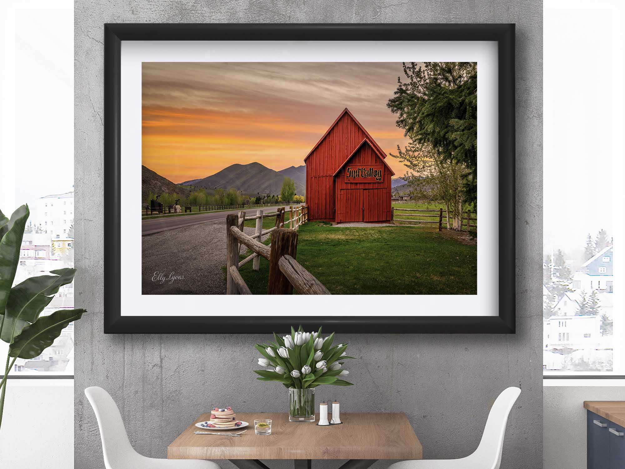Sun Valley Idaho red barn at sunset fine art print in black frame styled above a table and chairs in a bright dining room