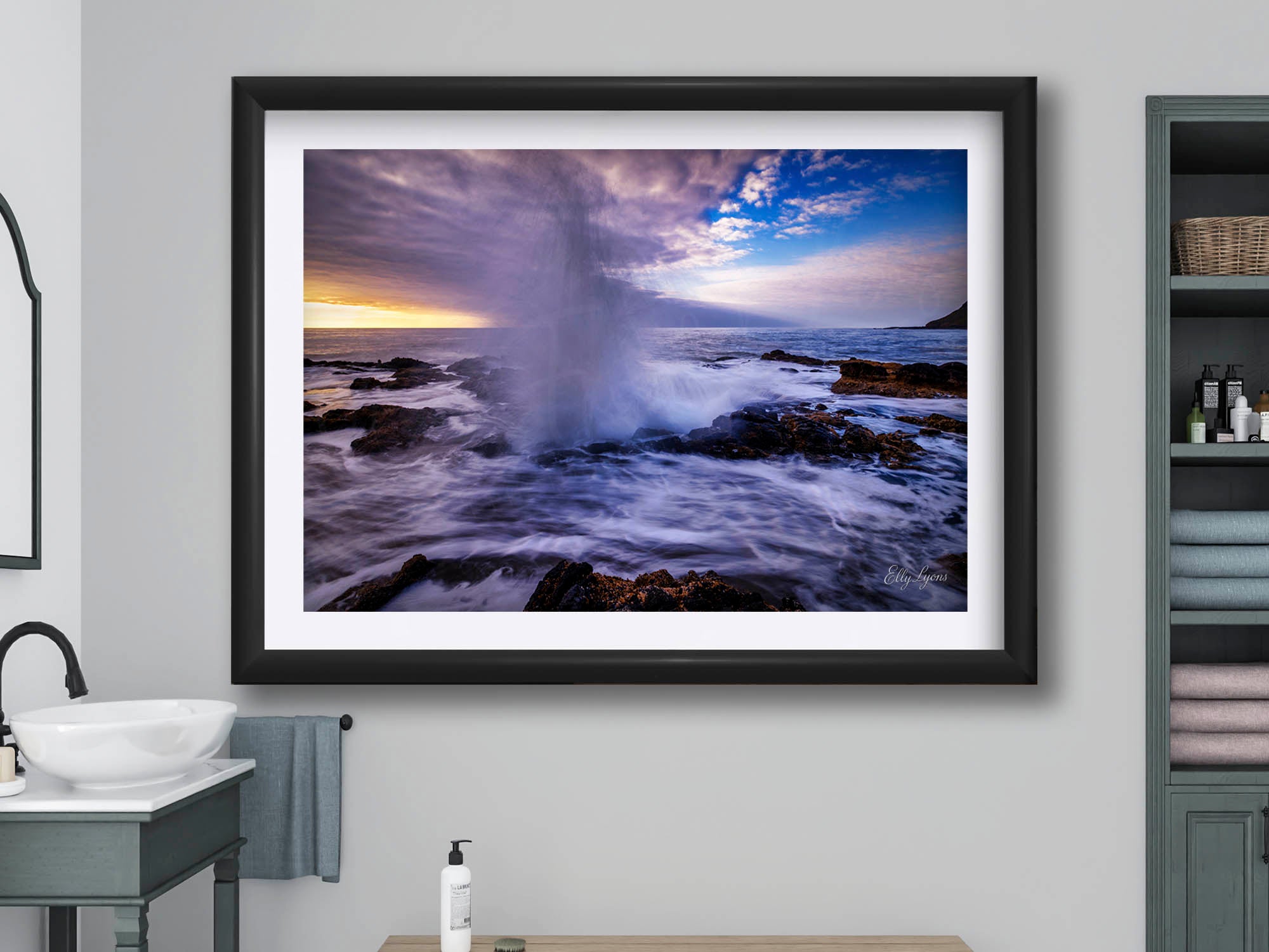 Oregon coast Thor’s Well sunset fine art print in black frame styled above a wooden bench in a bright bathroom