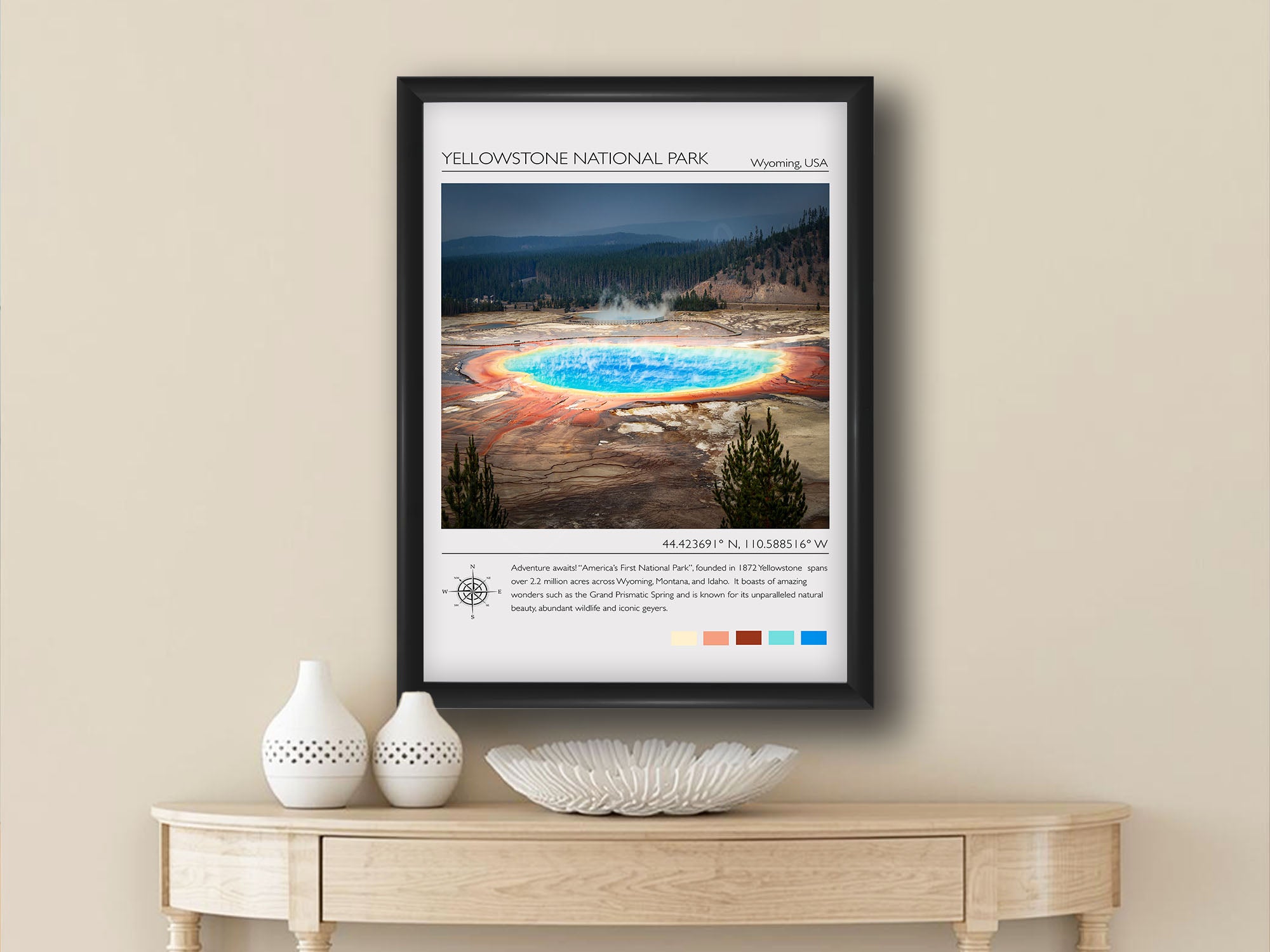 Yellowstone National Park travel poster featuring Grand Prismatic Spring photograph and photo inspired color palette in black frame styled above a wooden table in a bright entryway